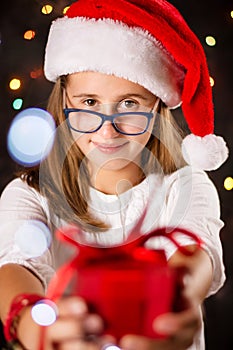 Teenage girl with Santa hat holding a present