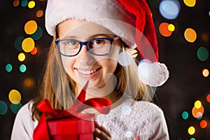 Teenage girl with Santa hat holding a present