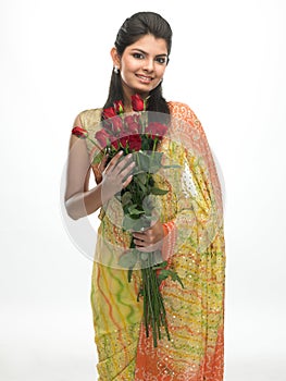 Teenage girl in sari holding red roses