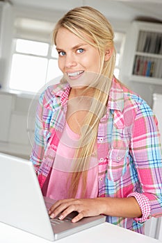 Teenage girl sat using laptop