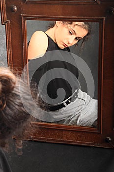 Teenage girl in school clothes mirroring in mirror