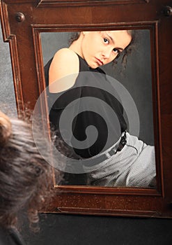Teenage girl in school clothes mirroring in mirror