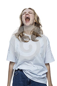 A teenage girl screams. Young pretty blonde in a white T-shirt and jeans. Depression and horror. Isolated on white background.