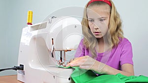 A teenage girl sews braid to the edge of a piece of cloth