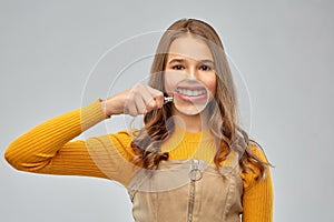 Teenage girl shows teeth through magnifying glass