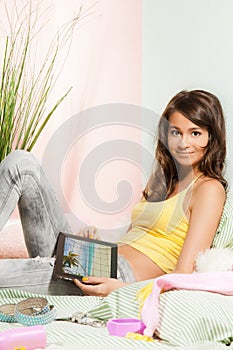 Teenage girl sitting in bed tablet computer