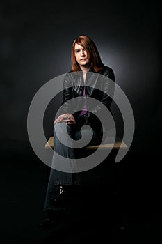 Teenage girl sitting on desk