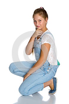 A teenage girl is sitting on the floor.