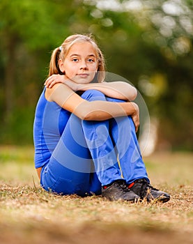 Teenage girl sitting on green