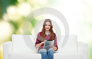 Teenage girl sitting on sofa with tablet pc