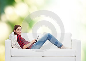 Teenage girl sitting on sofa with tablet pc