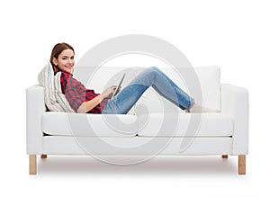 Teenage girl sitting on sofa with tablet pc