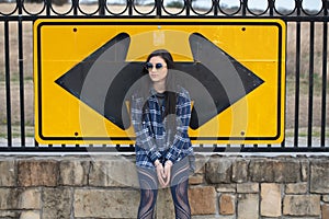 Teenage girl sitting on wall