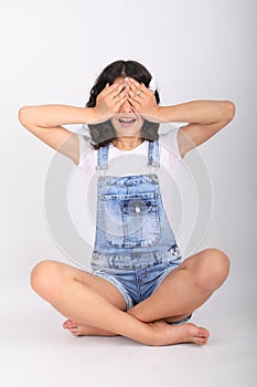 Teenage girl sitting in yoga easy pose and covering eyes