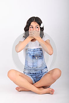 Teenage girl sitting in yoga easy pose and covering mouth