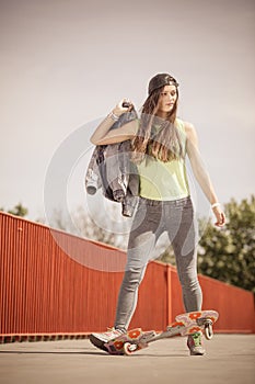 Teenage girl skater riding skateboard on street.