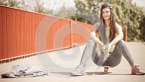 Teenage girl skater riding skateboard on street.