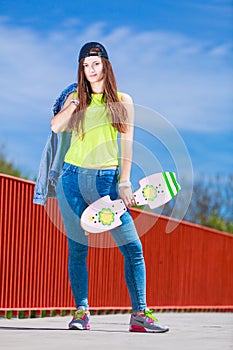 Teenage girl skater riding skateboard on street.