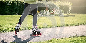 Teenage girl is skating on roller blades in the park