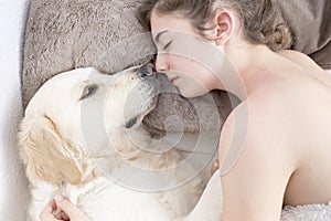 Teenage girl sleeping with her dog.