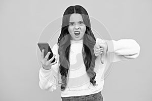 Teenage girl with smart phone. Portrait of teen child using mobile phone, cell web app. Angry face, upset emotions of