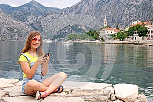 Teenage girl with smart phone on summer vacation