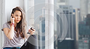 Teenage girl with smartphone and earphones