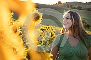 Teenage girl smiling while looking at sunflowers