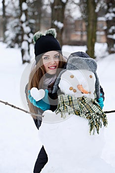 A teenage girl with a snowman