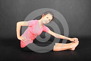 Teenage girl in sportswear bowing to toes