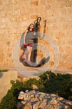 Teenage girl standing on an anchor