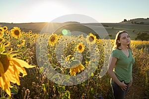 Teenage girl standing in front of sunflowers