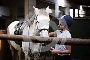 Teenage girl standing with horse