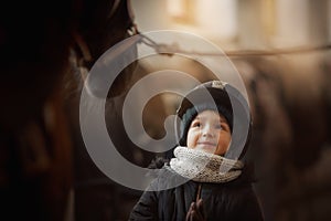 Teenage girl standing with horse in a stable
