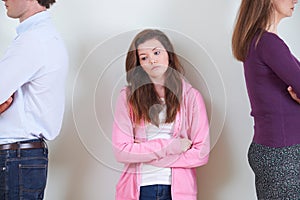 Teenage Girl Standing Between Parents Not Speaking To Each Other