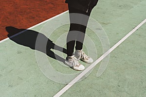 Teenage girl standing on rubberized sport ground