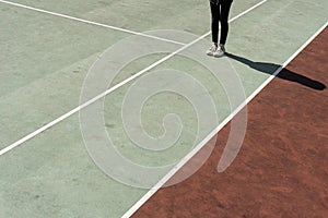 Teenage girl standing on rubberized tennis court