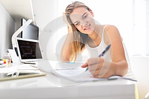 Teenage girl studing for school, doing homework photo