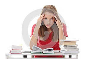 Teenage girl studying at the desk being tired