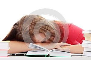 Teenage girl studying at the desk being tired