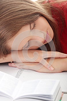 Teenage girl studying at the desk being tired