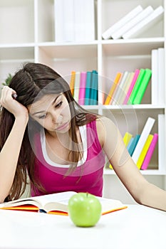 Teenage girl studying at the desk being tired