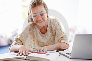 Teenage Girl Studying On Laptop At Home