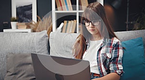 Teenage girl studying laptop, home