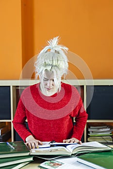 Teenage girl studying reading book at home concentrating looking