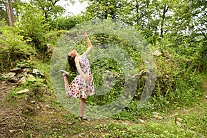 Teenage girl in summer dress dancing in front of ruins