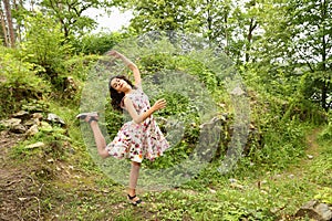 Teenage girl in summer dress dancing in front of ruins