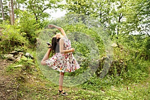 Teenage girl in summer dress dancing in front of ruins