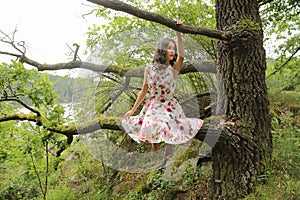 Teenage girl in summer sitting on branch