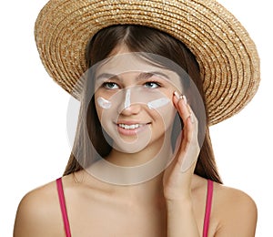 Teenage girl with sun protection cream on her face against white background